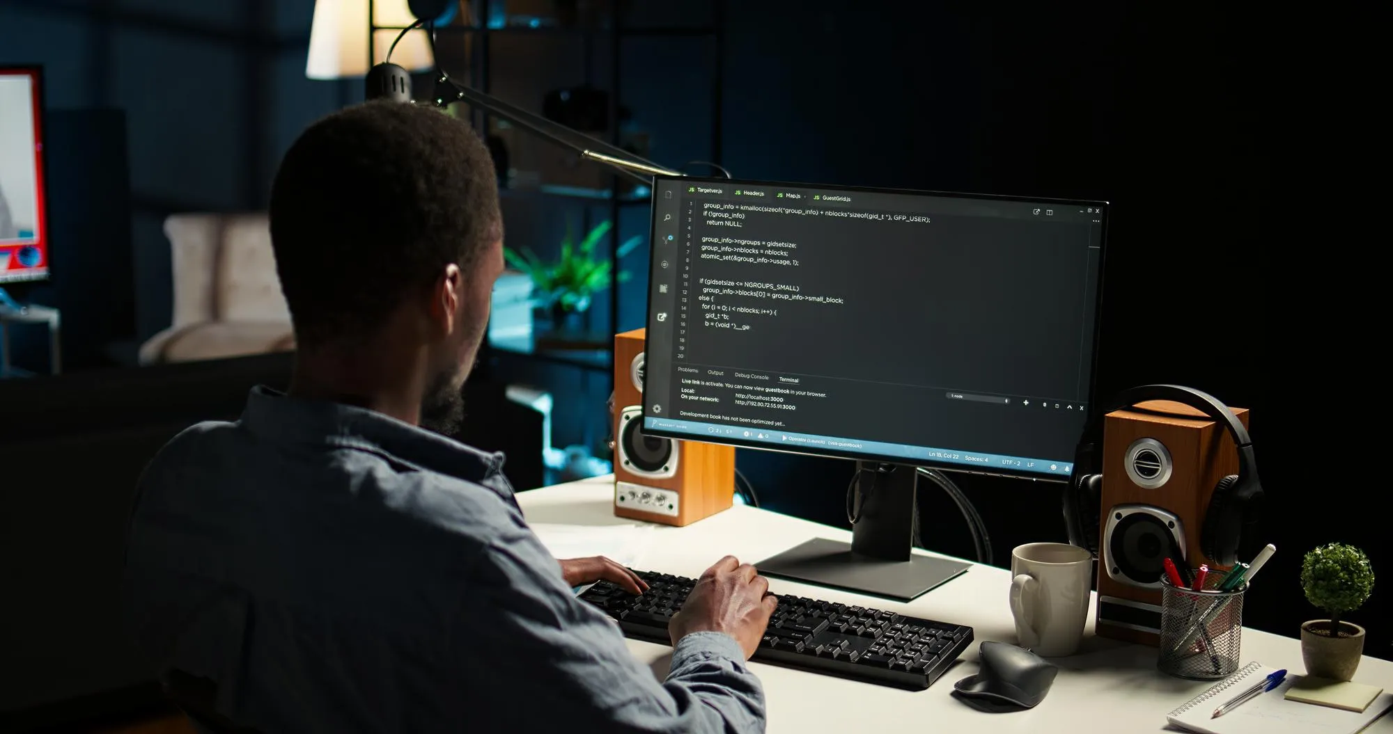 A developer at a desk with code on two monitors.