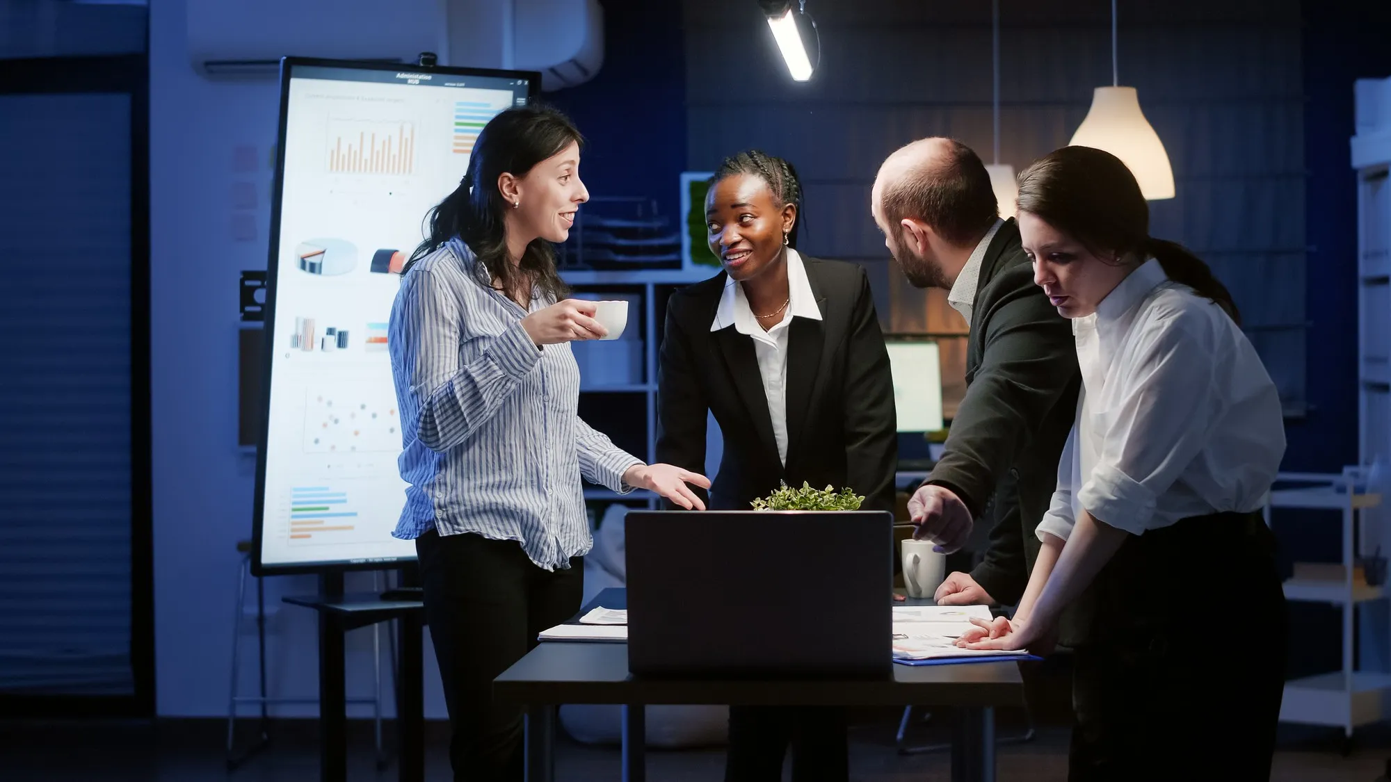 A marketing team gathered around a laptop, reviewing a campaign together.